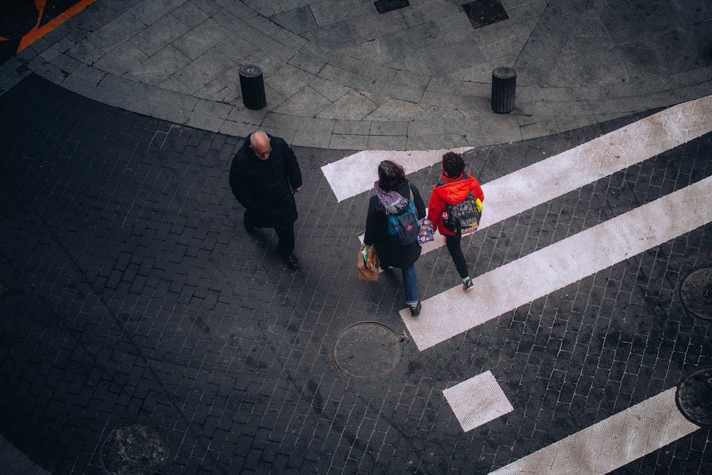 High-angle view of people crossing a street in Bilbao, Spain, showcasing urban life.